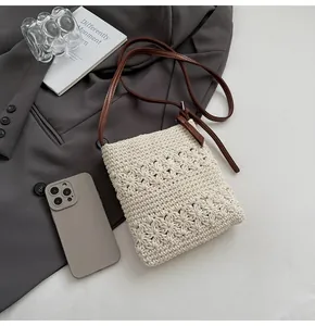 Close-up of hand-woven floral crochet texture on cream bucket bag with brown strap