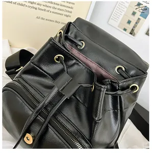 Nahaufnahme von schwarzem Lederrucksack mit Kordelzug und goldenen Metallteilen