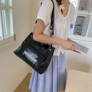 Classic black glossy faux leather shoulder bag for women with chain strap and dual buttons