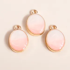 Three pieces of oval drip oil jewelry pendants with pink gradient and gold plating