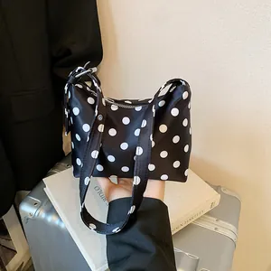 Chic black canvas bucket bag with white polka dots and matching wide shoulder strap