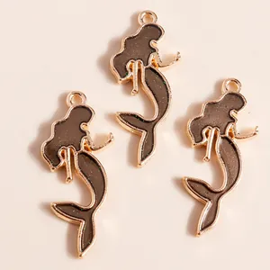 Detailed view of alloy mermaid charms with gold plating and glittering brown enamel