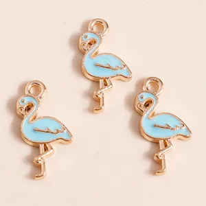 Détail de breloques flamants roses bleu clair émaillés avec bords dorés pour bijoux DIY