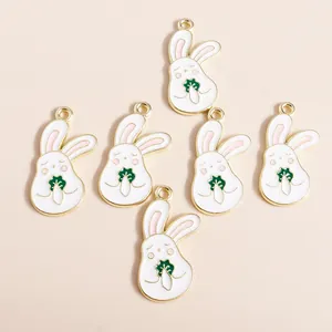 Detailed view of six cartoon white rabbit pendants with gold edges and green vegetables