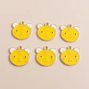 Detailed view of yellow tiger head enamel charms with gold edges and hanging loops