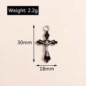 Dettaglio di un ciondolo a croce vintage 30x18mm con smalto nero e figura di Gesù