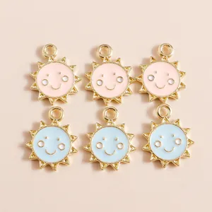 Gros plan de pendentifs soleil souriant en émail rose et bleu avec placage doré DIY