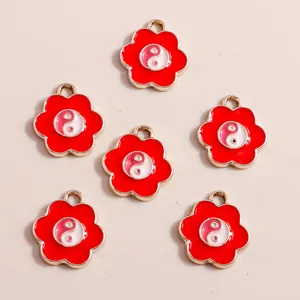 Detail of red flower charms with Yin Yang symbol and golden alloy frame for DIY jewelry