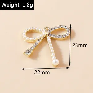 Détail macro d'un pendentif nœud élégant avec perles et strass mesurant 22mm x 23mm