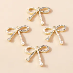 Détail macro de quatre pendentifs nœuds dorés avec pierres œil de chat et petites perles