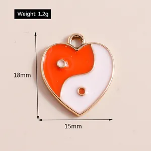 Detail view of heart-shaped Tai Chi pendant with orange enamel and gold plating