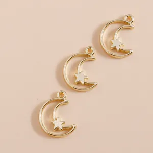 Drie gouden maan- en sterhangers voor doe-het-zelf sieraden op beige achtergrond