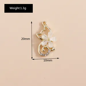 Dettaglio di un ciondolo a gatto da 20mm in oro con fiore bianco, strass e misure