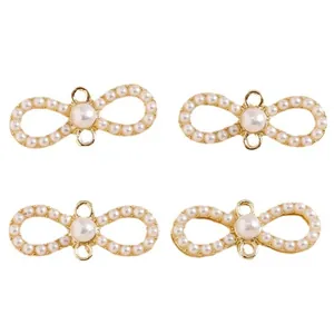 Elegant infinity-shaped bow pendant with white faux pearls and gold finish settings