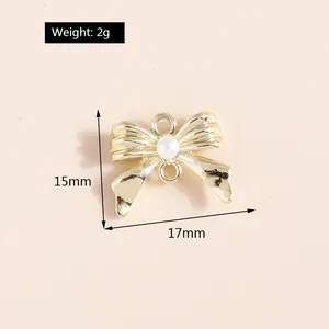 Detalle de colgante de lazo dorado de 15x17mm con perla de opale y diamantes