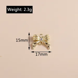 Detalle macro de colgante de lazo dorado con opalo y diamantes muestra medidas de 17x15mm