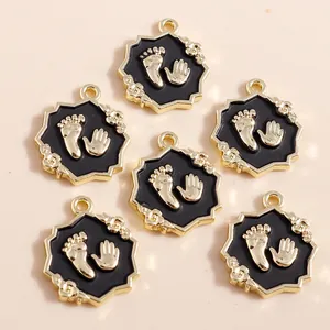 Set de 6 colgantes octagonales dorados de esmalte negro con huellas de manos y pies