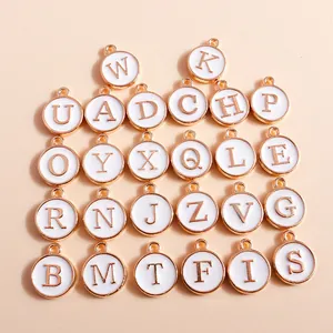 Set of 26 gold alloy initial charms with white enamel lettering for DIY jewelry making