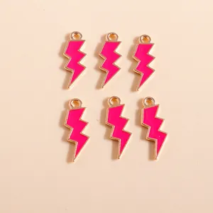 Detalle de seis colgantes de rayo con acabado en esmalte rosa para creación de joyas DIY