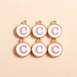 Detailed view of light pink enamel letter C pendants with gold trim for DIY jewelry