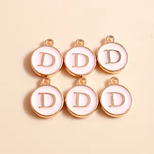 Macro shot of 6 pink enamel letter D charms with gold metal edges for DIY jewelry