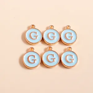 Macro shot of 6 light blue enamel round pendants with rose gold letter G for DIY jewelry