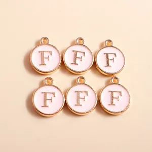 Detail of pink enamel round charms with gold letter F for DIY jewelry making