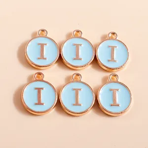 Macro detail of light blue enamel round charms with rose gold letter I for DIY jewelry