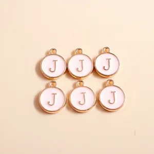 Detail view of 6 round pink enamel charms with golden letter J and top loops for DIY crafts