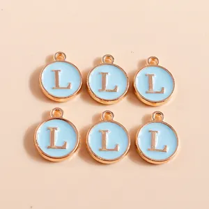 Macro detail of six light blue enamel alphabet L charms with gold-plated metal borders