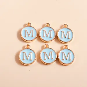 Detailed view of six light blue enamel round M-letter charms with gold plating for DIY crafts