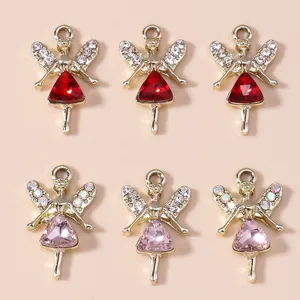 Vue détaillée de breloques ange dorées avec cristaux rouges et roses et ailes papillon