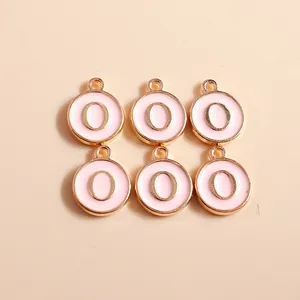 Macro shot of 6 pink enamel letter O pendants with gold metal edges for DIY jewelry