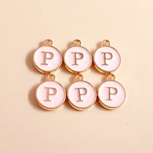 Detailed view of six pink enamel and gold-plated alloy round charms with letter P