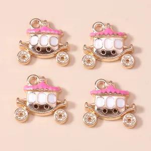 Detailed close-up of four pink and gold enamel pumpkin carriage charms for DIY jewelry