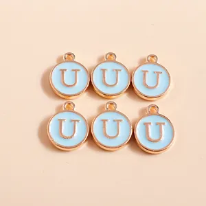 Detailed macro view of six gold-plated light blue enamel round letter U charms for DIY jewelry