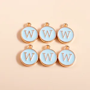 Detail of blue enamel round letter W charms with gold finish for DIY jewelry