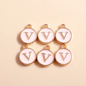 Detailed macro view of 6 gold enamel charms with letter V for DIY jewelry making