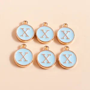 Detailed macro view of gold-plated enamel letter X charms for DIY jewelry making
