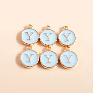 Close-up of circular light blue enamel charms with gold trim and golden letter Y