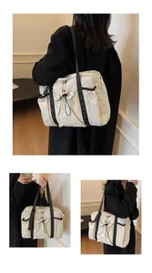 Detailansicht der beigen Pendlertasche mit Kordelzugtaschen und dreifarbigem Bandelement
