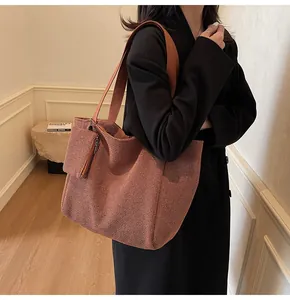 Brown houndstooth tote bag with small matching zipper pouch shown on person's shoulder