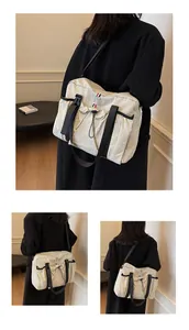 Detailansicht der beigen Canvas-Tasche mit verstellbarem Gurt und Kordelzug-Seitentasche