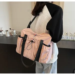 Seitenansicht der rosa Canvas-Tasche mit Kordelzug und schwarzen Trägern am Modell