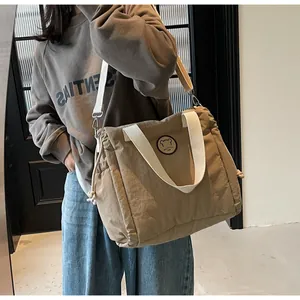 Dettaglio della borsa tote kaki con logo orso e coulisse laterale funzionale