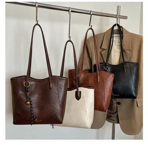 Row of textured leather tote bags in four colors hanging on a vintage metal rack