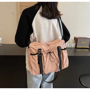 Rosafarbene Nylon-Umhängetasche mit Kordelzug und verstellbarem Riemen am Modell