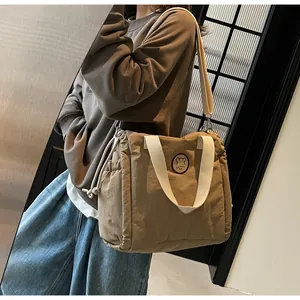 Dettaglio della borsa tote trapuntata kaki con coulisse laterale e motivo a orsetto