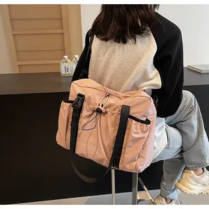Rosafarbene Nylon-Tragetasche mit Kordelzugtasche und dreifarbigem Gurt am Körper