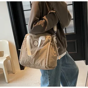 Borsa tote kaki con toppa a forma di orso indossata da una modella in un contesto casual